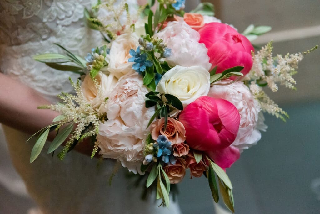 Bridal bouquet with florals in creams, light pinks and peaches with a pop of bright pink