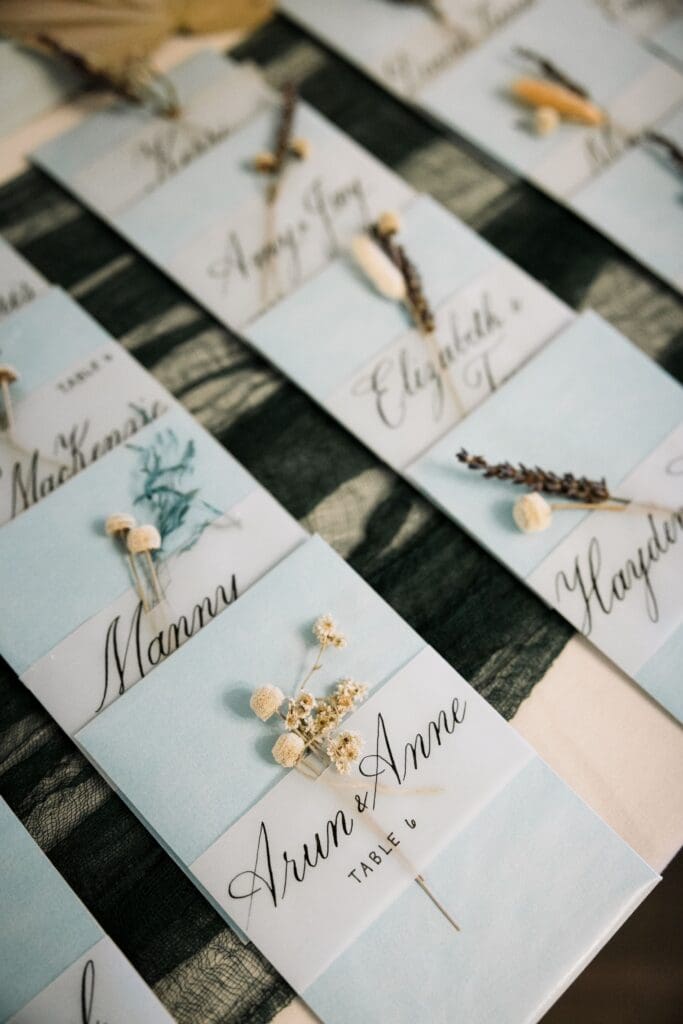 Escort cards with name and table numbers and small dried flower
